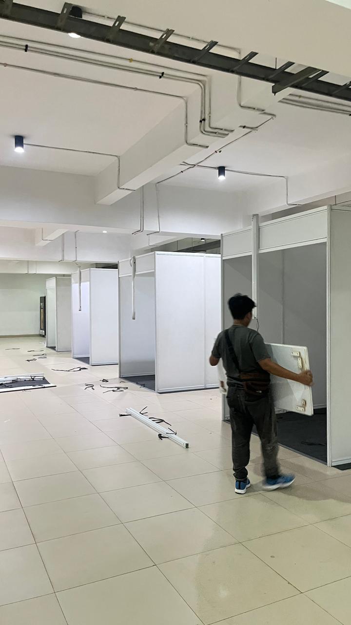 Tim Zein Event Production memasang partisi booth pameran dengan rapi.